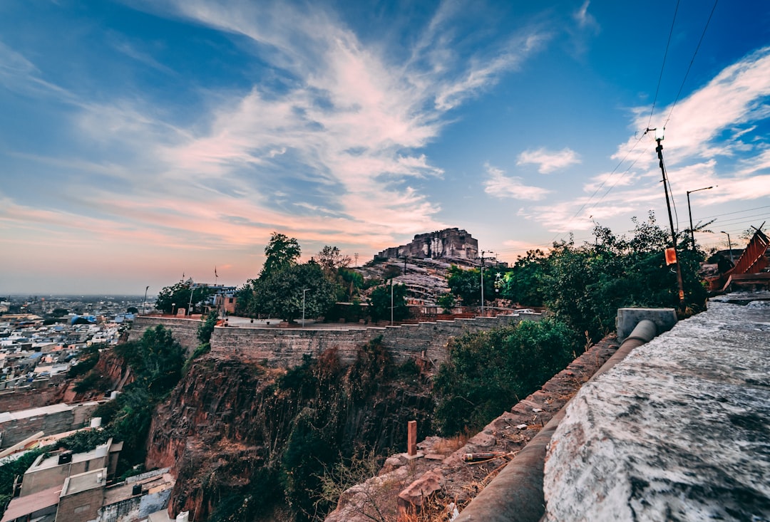 houses beside rock formation with trees during daytime