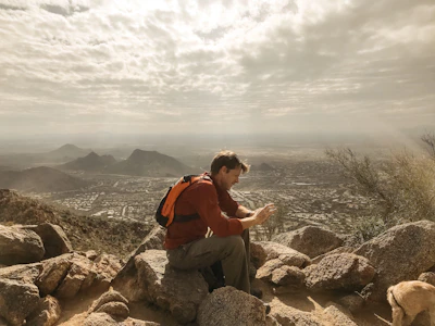 A traveler enjoying a scenic view while checking travel details on a tablet.