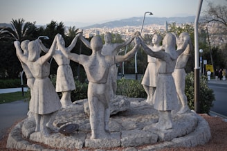 A circle of hands joined together over a mosaic of vibrant stones.