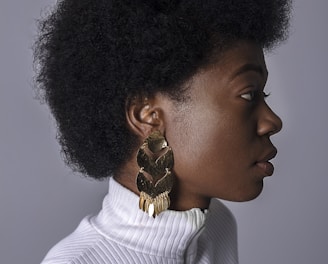 woman wearing white turtleneck top and gold-colored earring