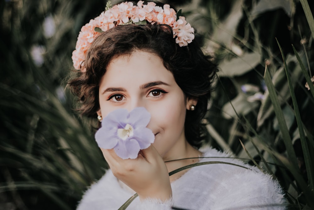 woman smelling purple flower