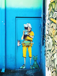 blue and yellow person taking camera painted door