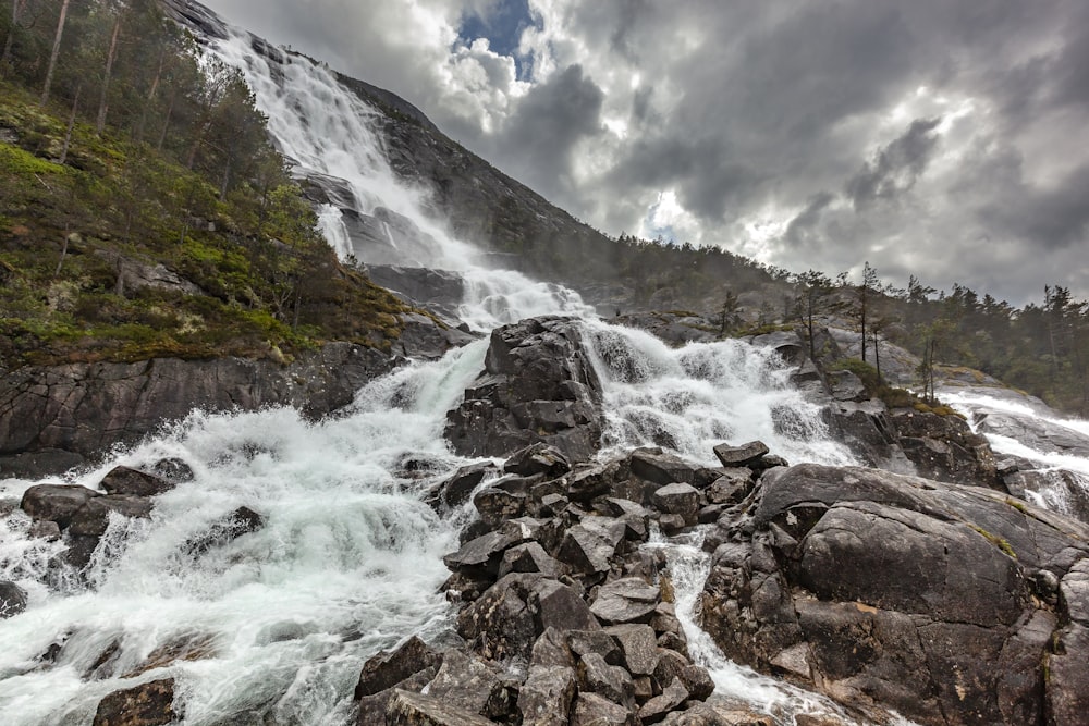 water falls splashing on rocks during daytime