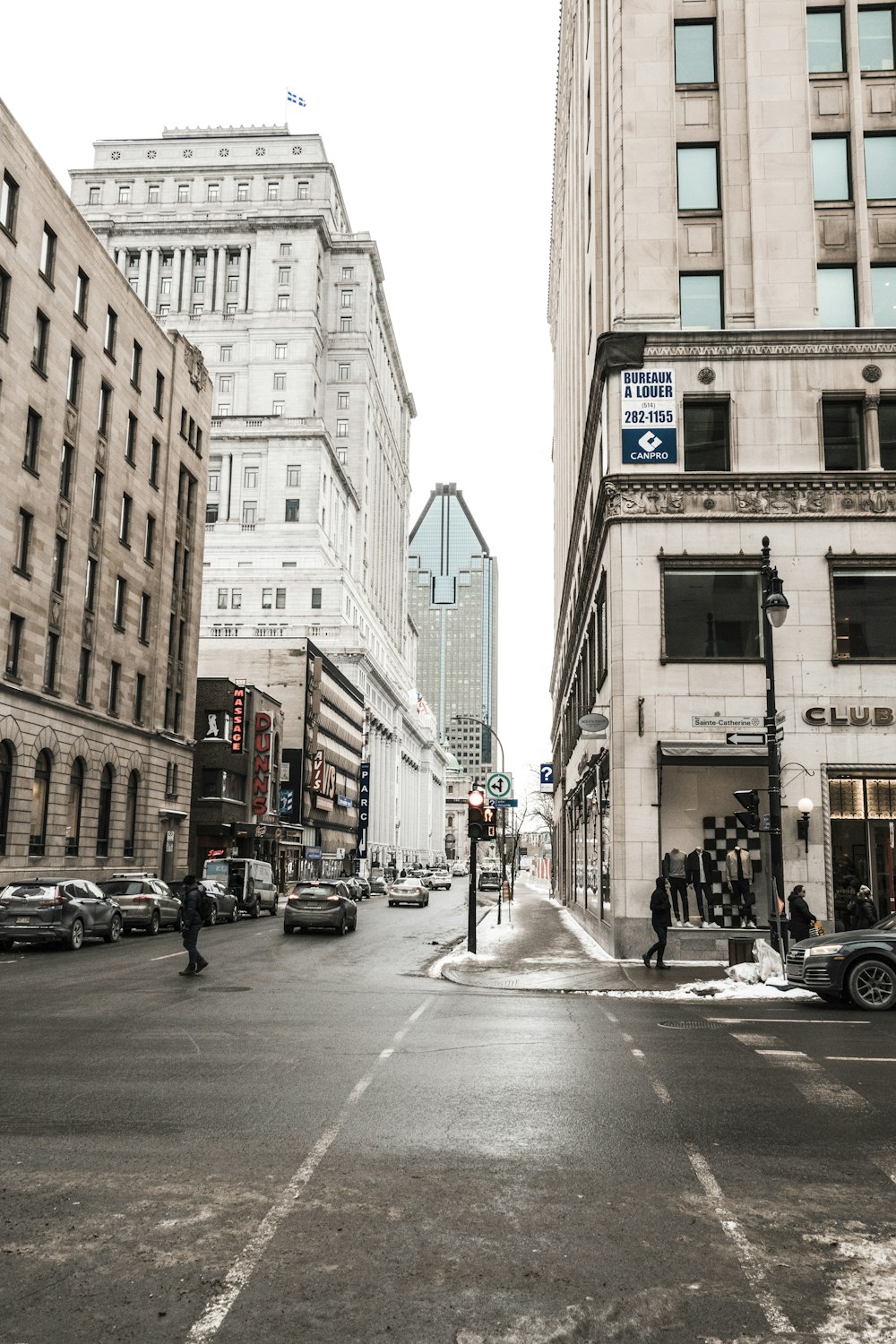 people walking on street with vehicle park beside buildings