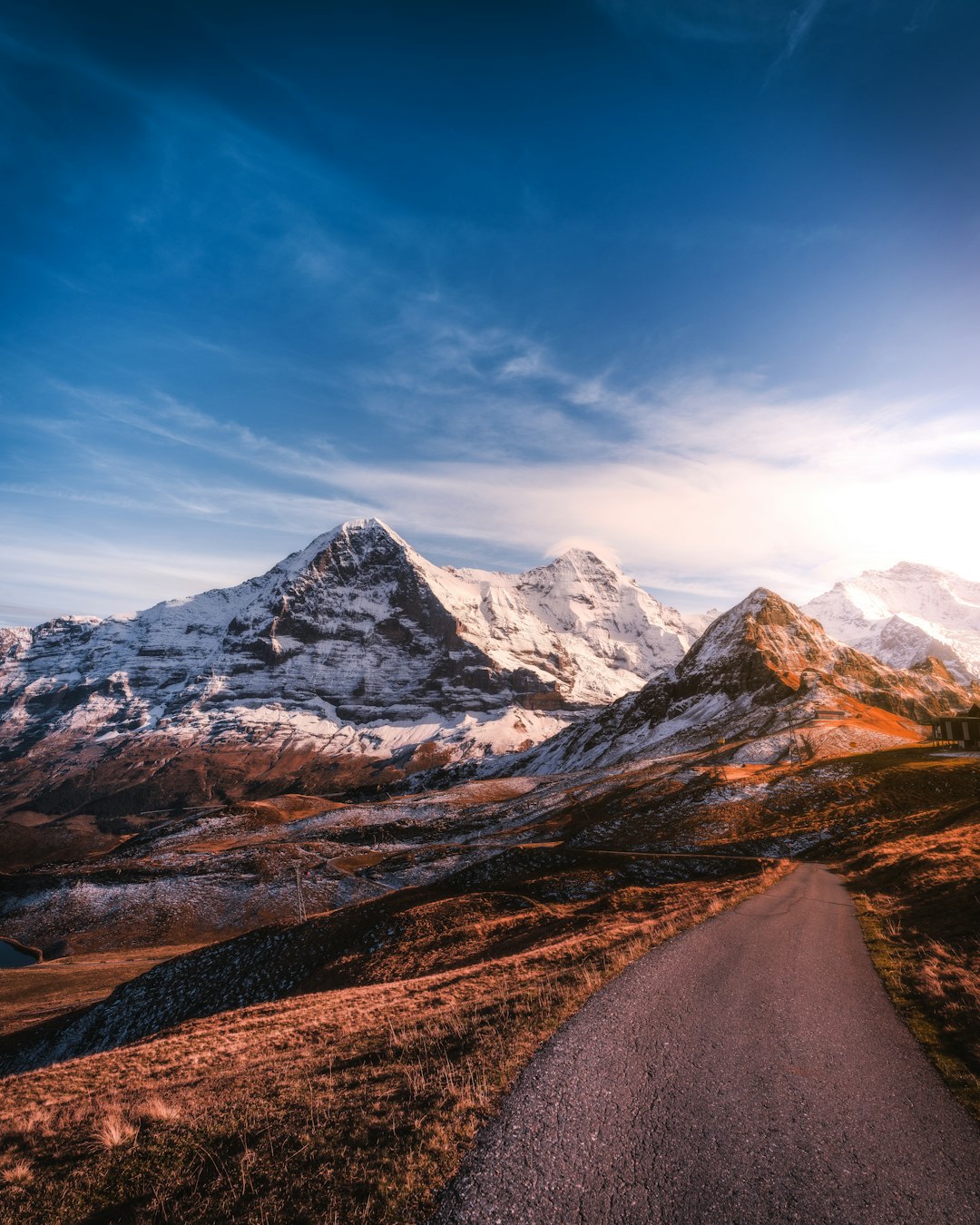 roadway beside iced capped mountain during daytime