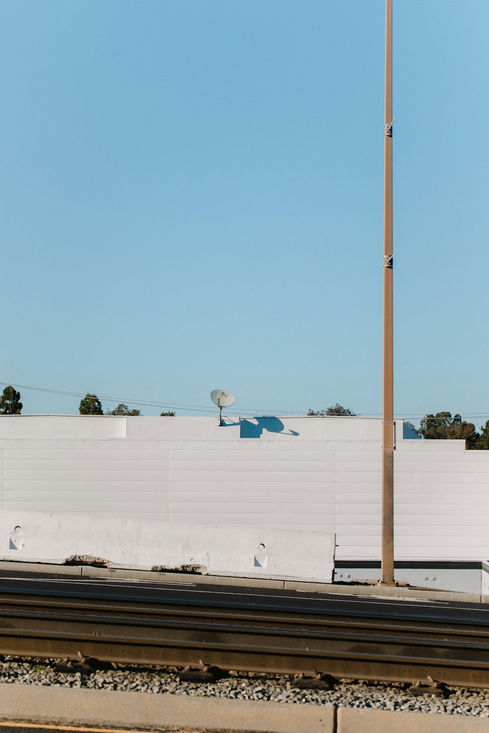 white satellite dish on roof near the rail tracks