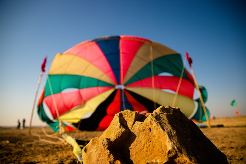 a hot air balloon sitting on top of a sandy beach