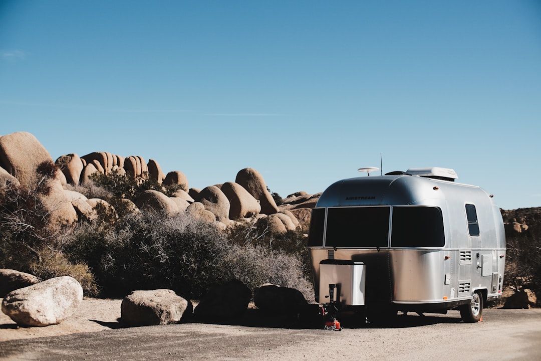 gray travel trailer parked beside brown rocks