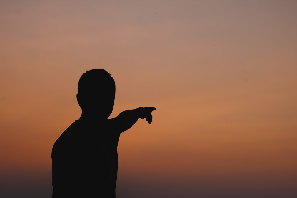 silhouette of person pointing hand
