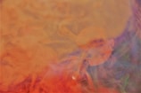 A colorful and abstract visualization characterized by swirling patterns of orange, yellow, purple, and green. The shapes and colors blend seamlessly, creating a dynamic and fluid appearance.