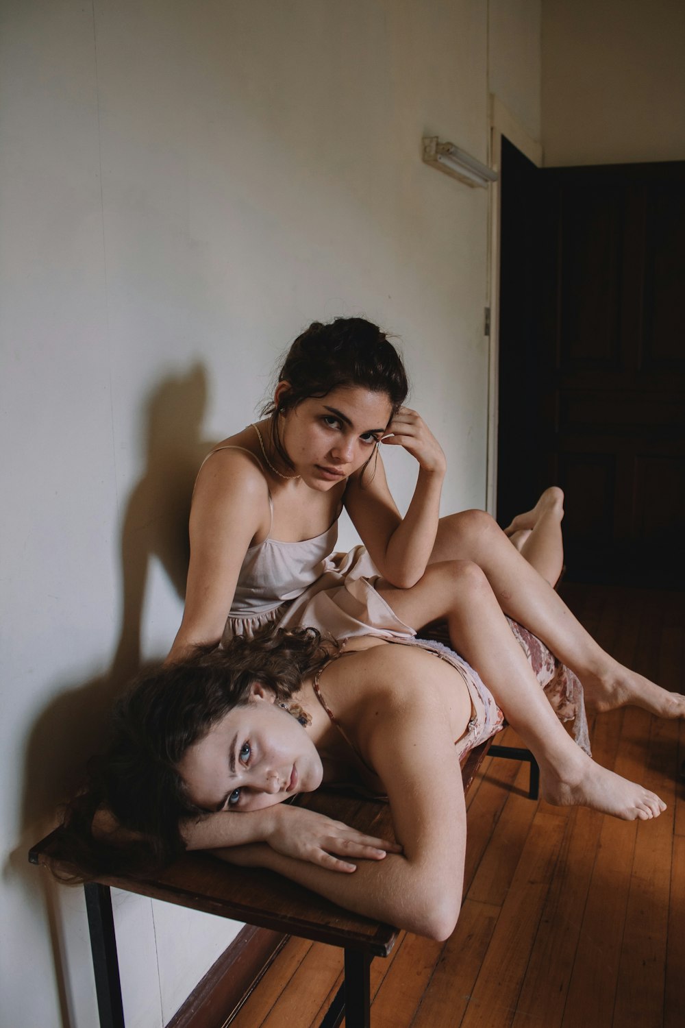 two women sitting and lying on brown table