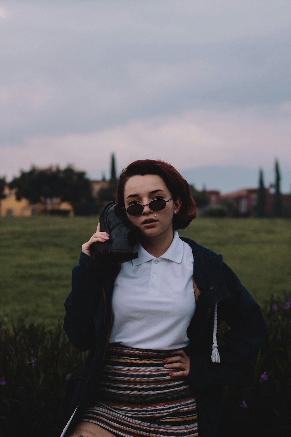 woman holding shoe standing beside plants