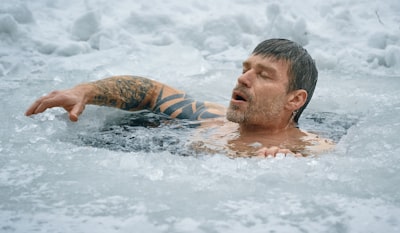 man swimming on frozen water tough teams background