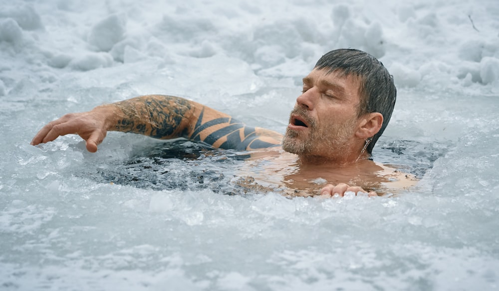 man swimming on frozen water