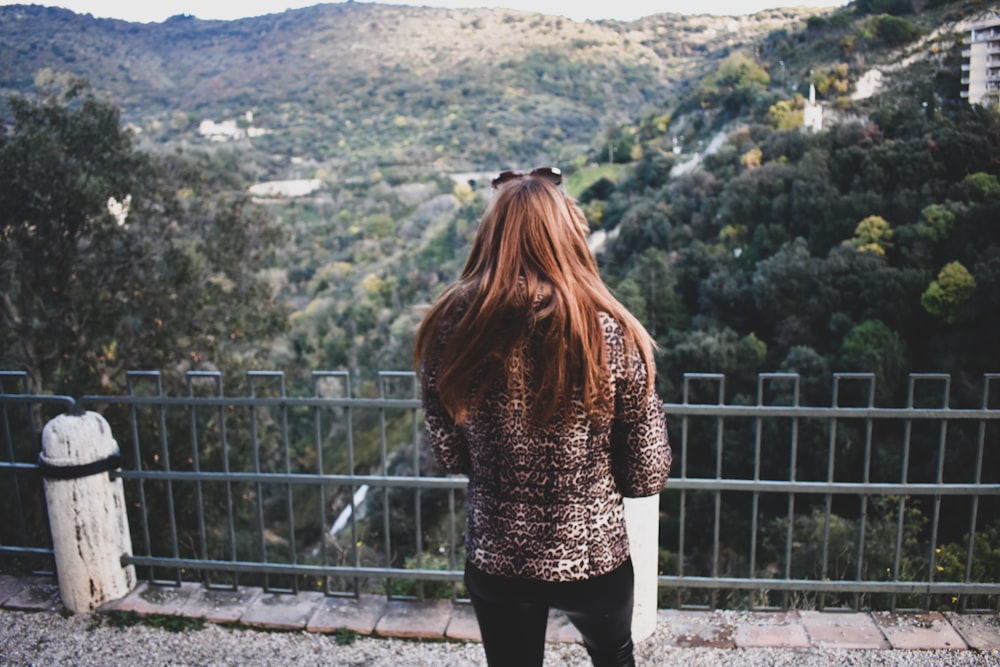 woman standing front of metal fence