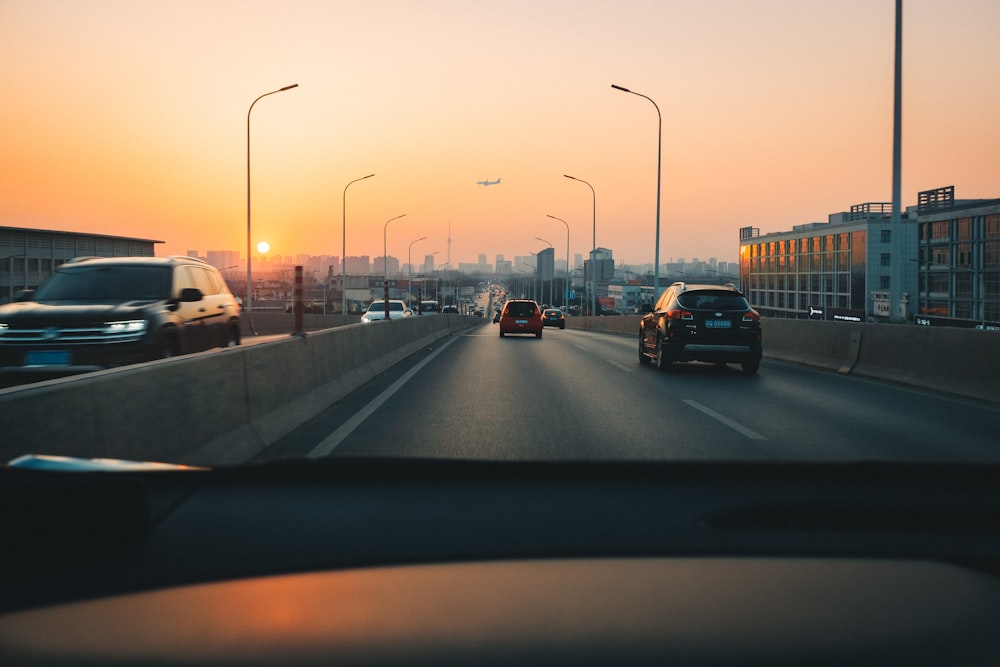 Coches en la carretera durante la puesta de sol