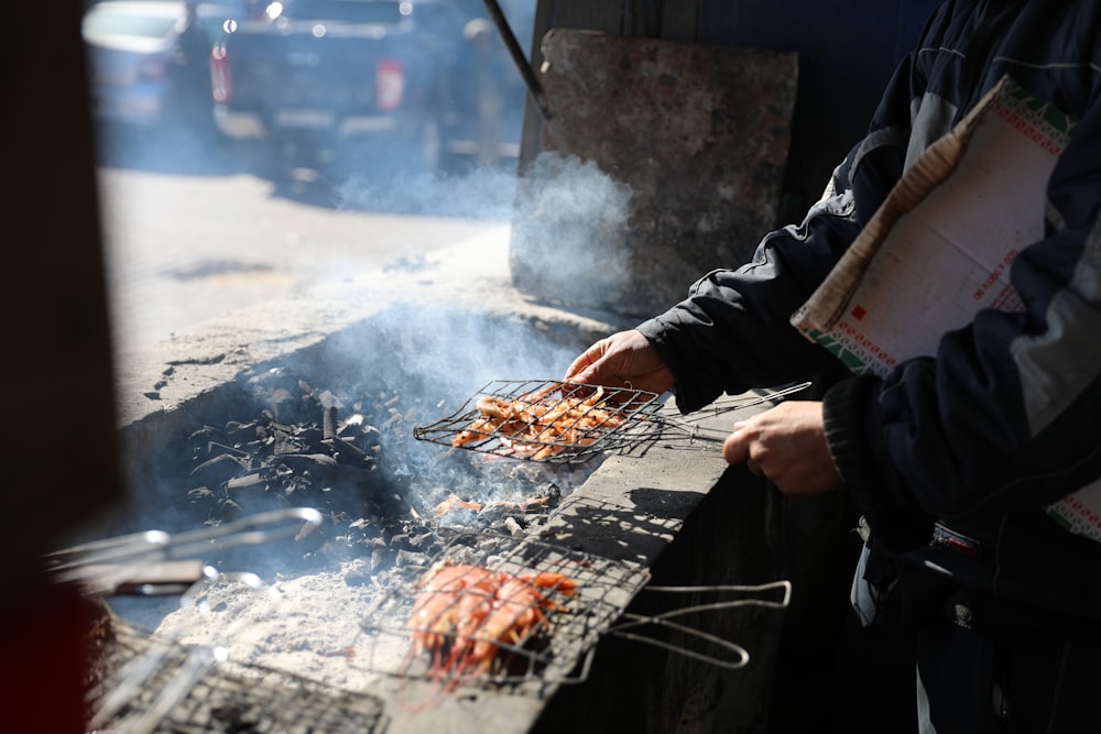 person grilling meat during daytime