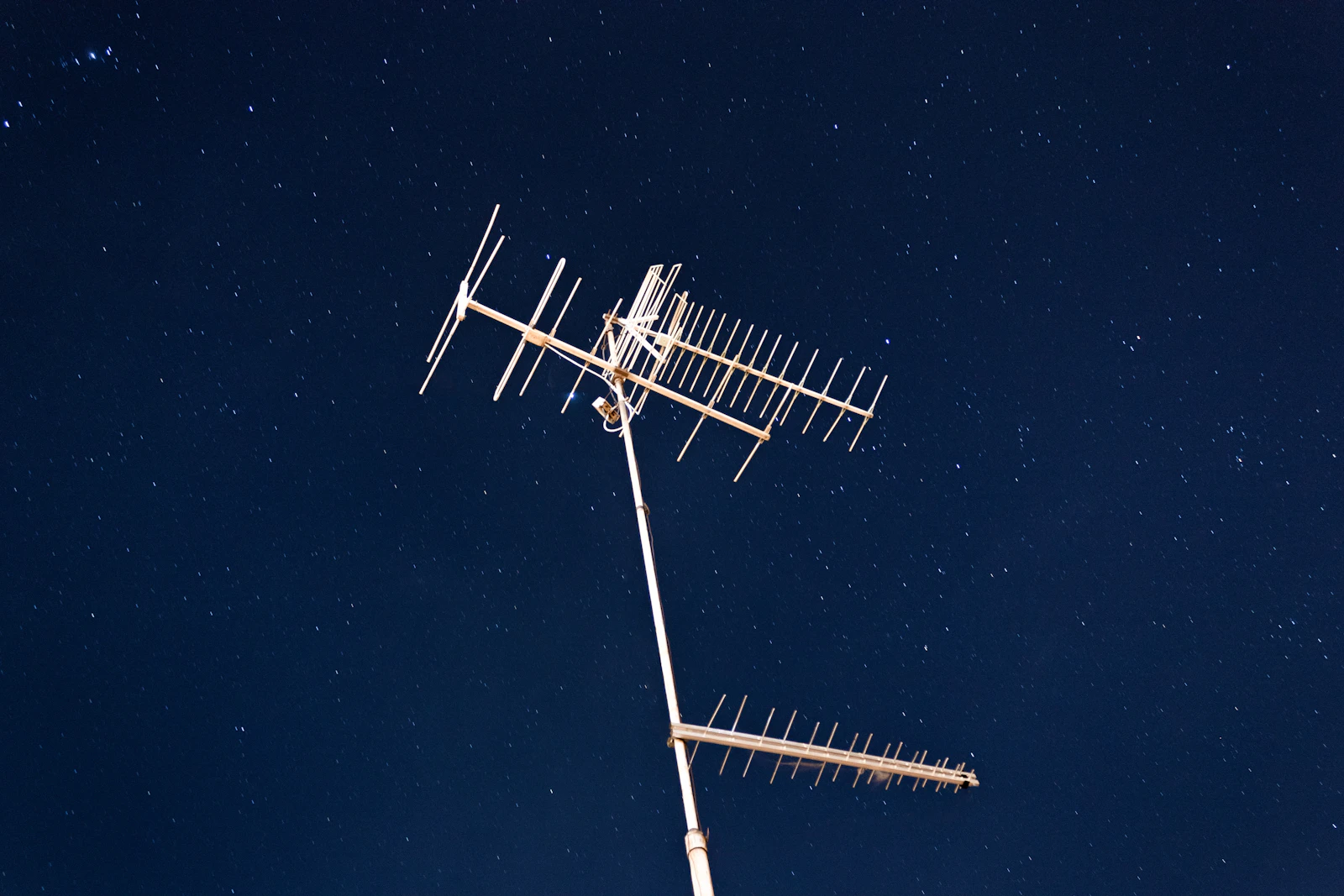 Glowing network of interconnected light points spreading across a dark background, resembling neurons or constellation patterns