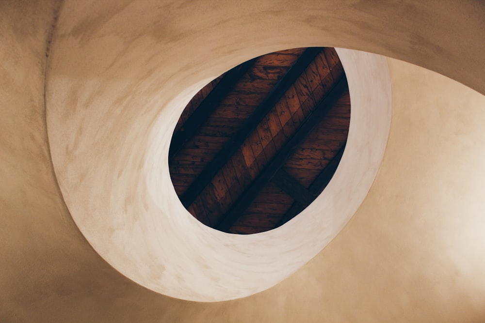 a round window in a white wall with a wooden ceiling