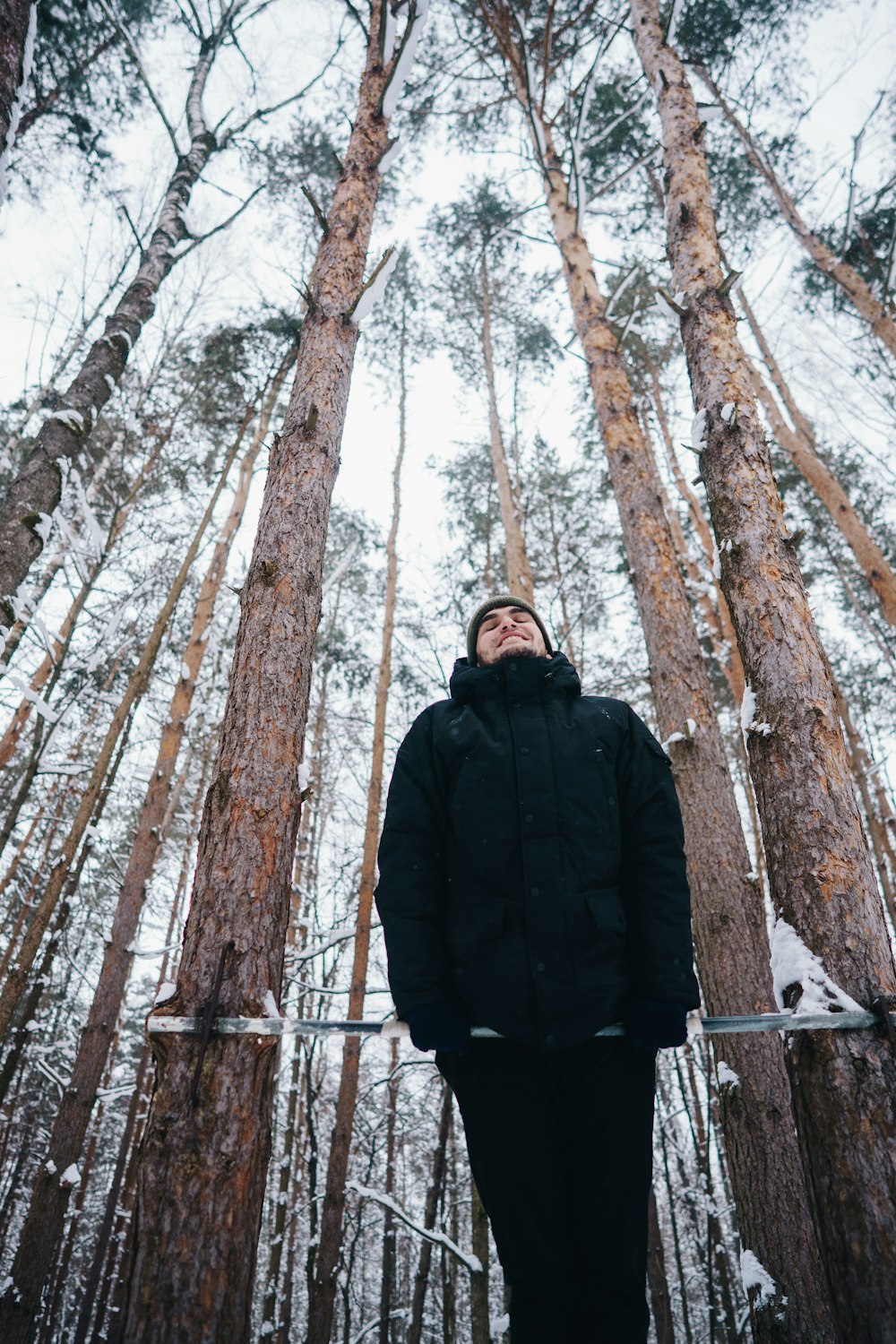 man in black jacket doing exercise near trees