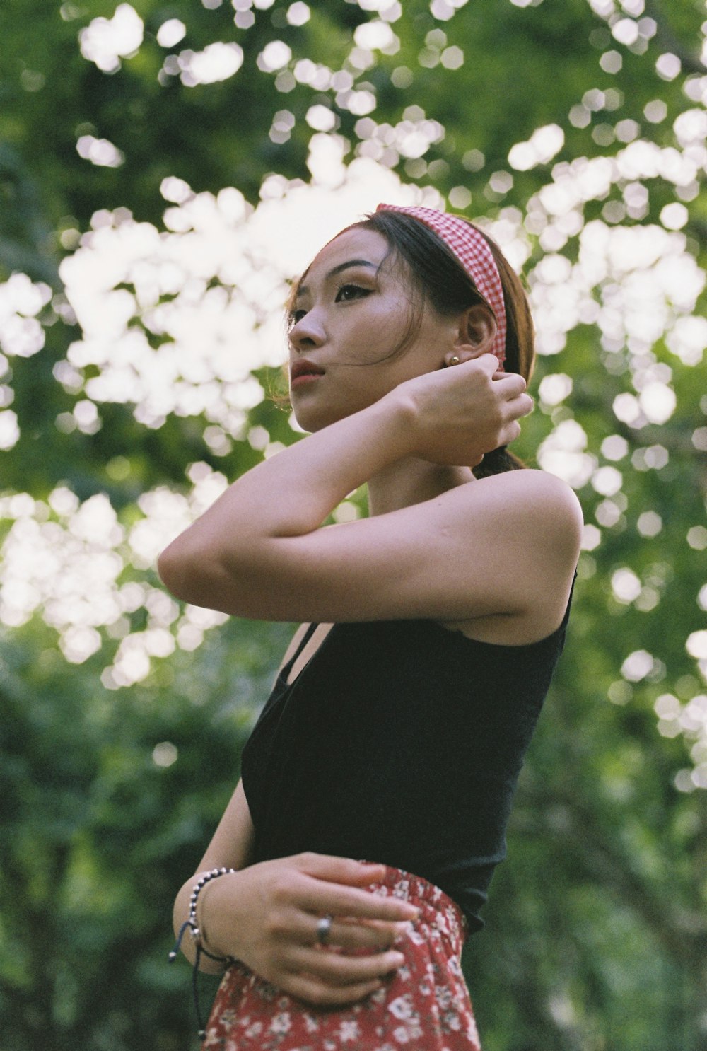 woman wearing black spaghetti strap top and red floral bottoms