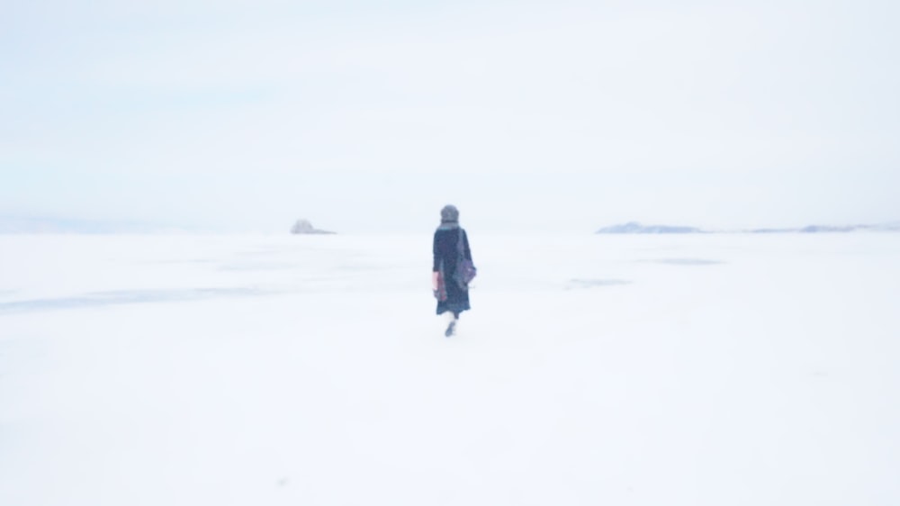 person walking on ground covered by snow