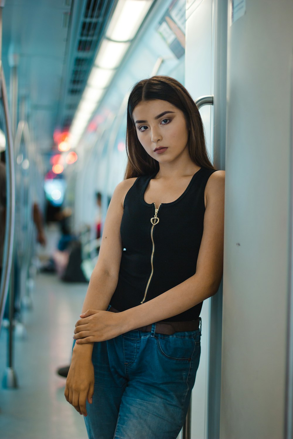 woman in black tank top and blue jeans leaning inside train