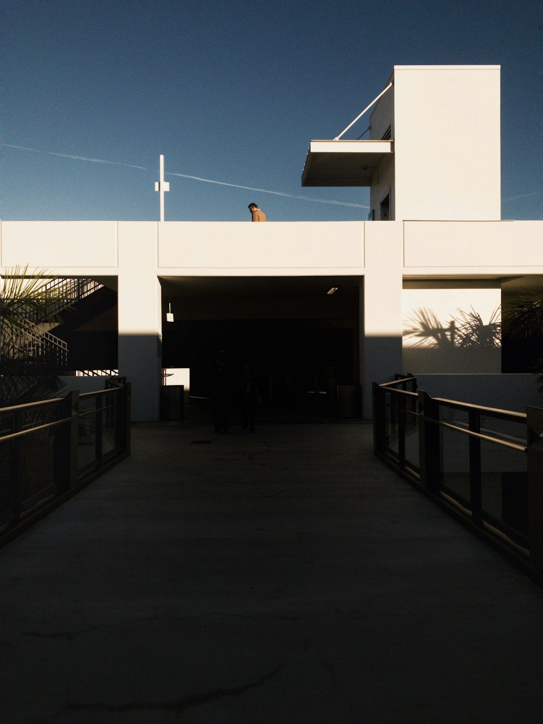 man in brown shirt standing on white concrete building