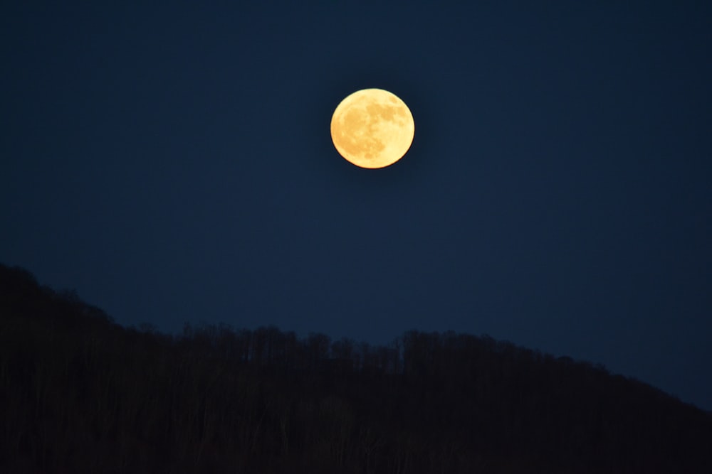 silhouette of mountain under moon