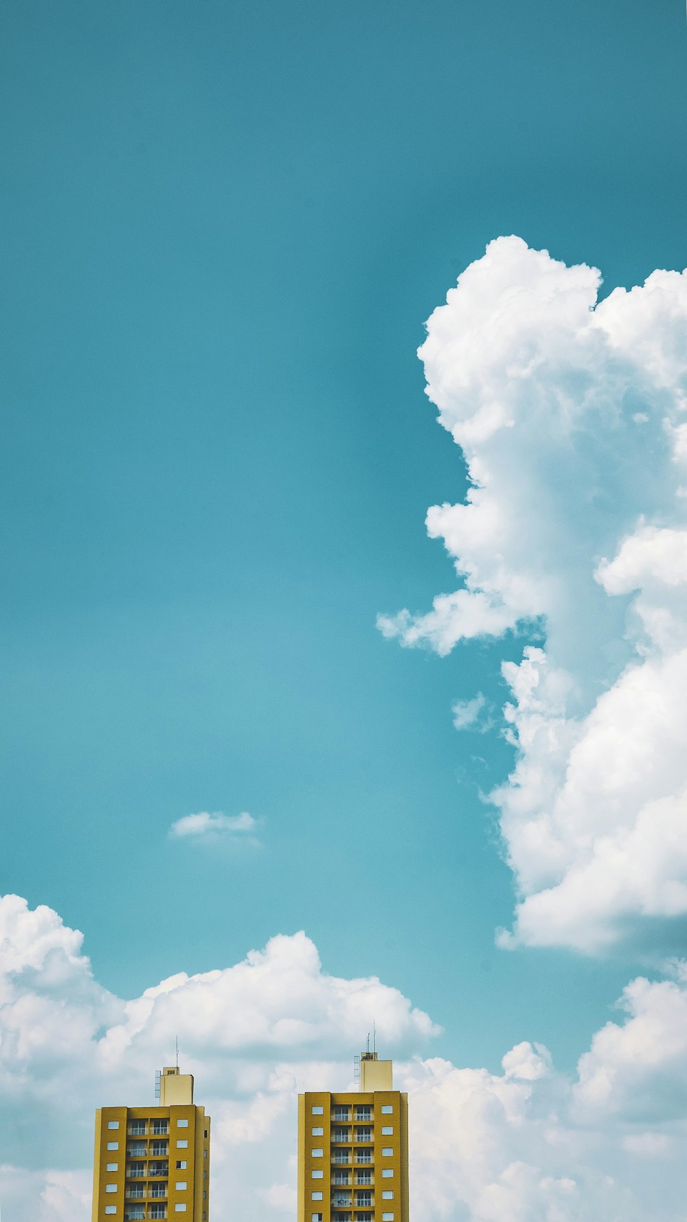 dois edifícios altos marrons sob o céu branco durante o dia