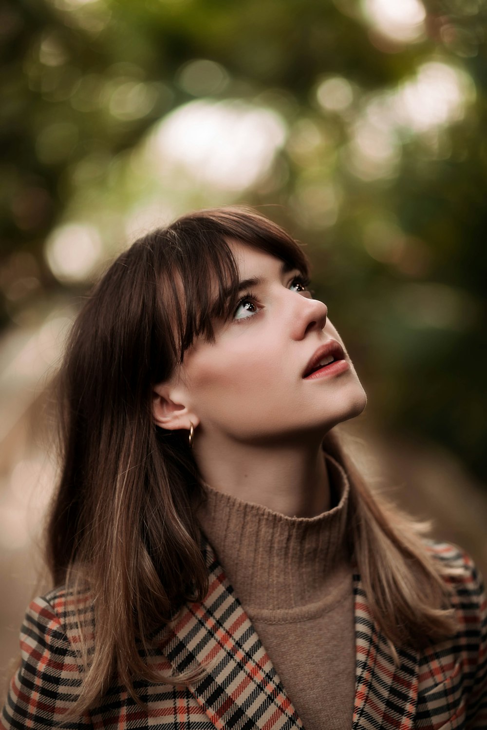 woman looking up in selective focus photography