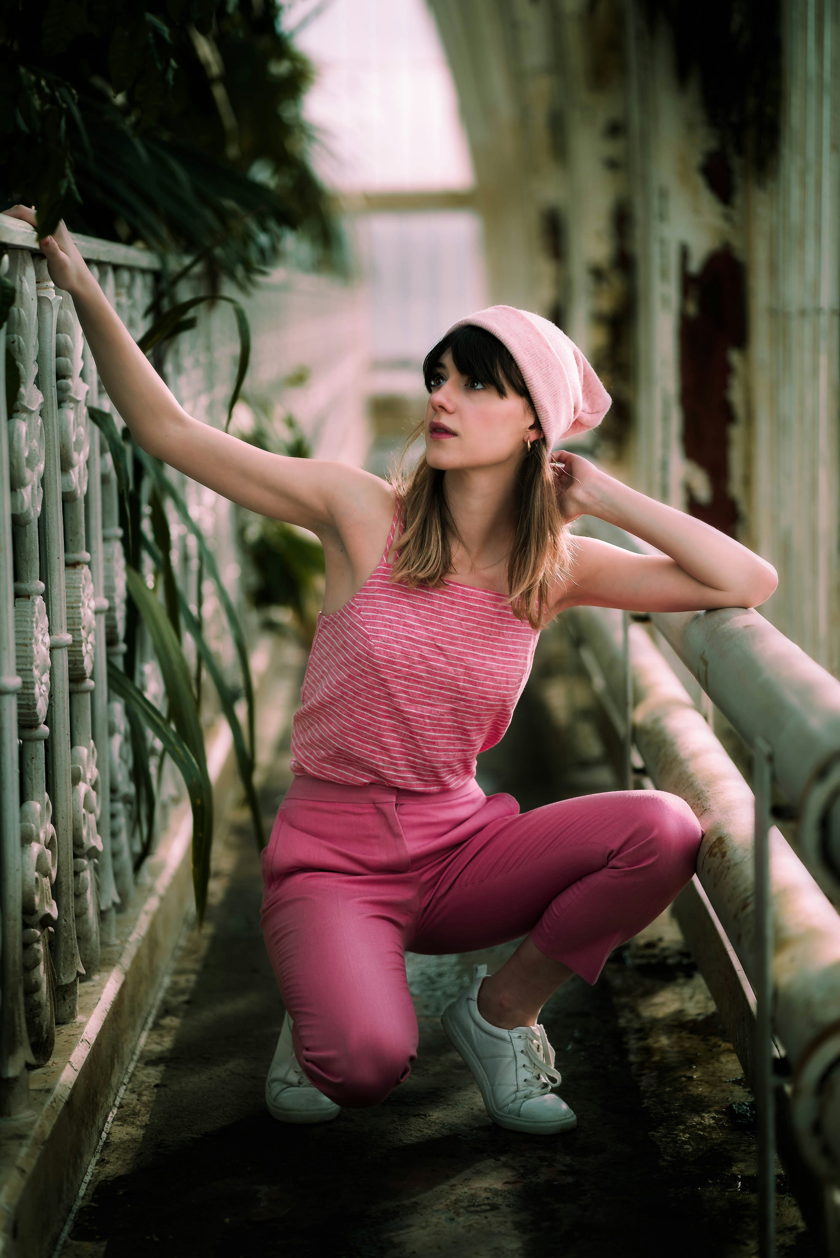 woman in pink pants sitting beside railings