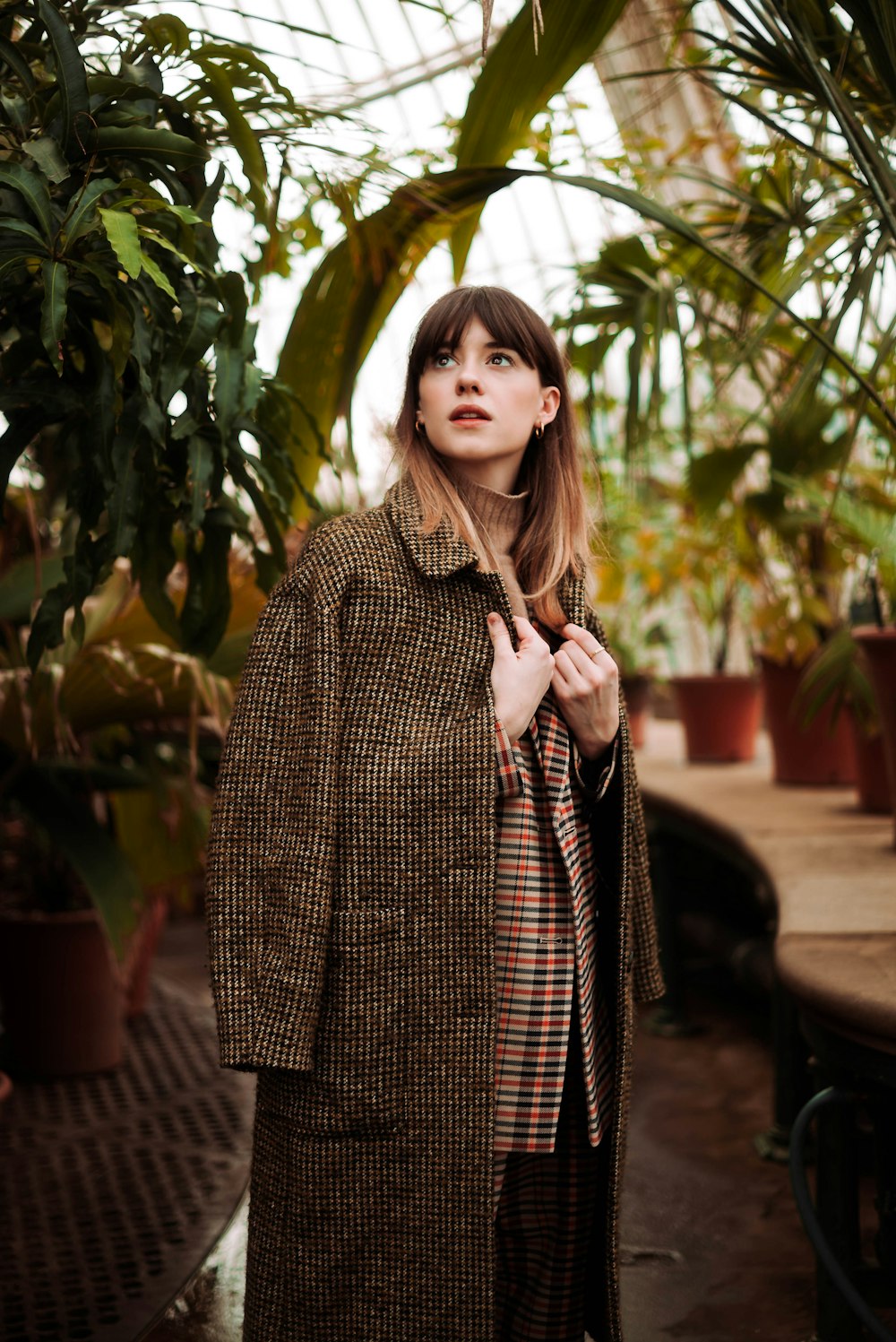 woman wearing brown coat near plants