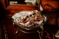 A collection of colorful beaded bracelets laid out on a wooden table with sunflower petals scattered around.
