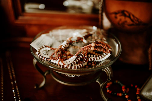 Artistic photo of porcelain bracelets stacked on a rustic wooden table.