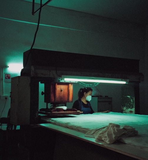 woman wearing face mask near industrial machine