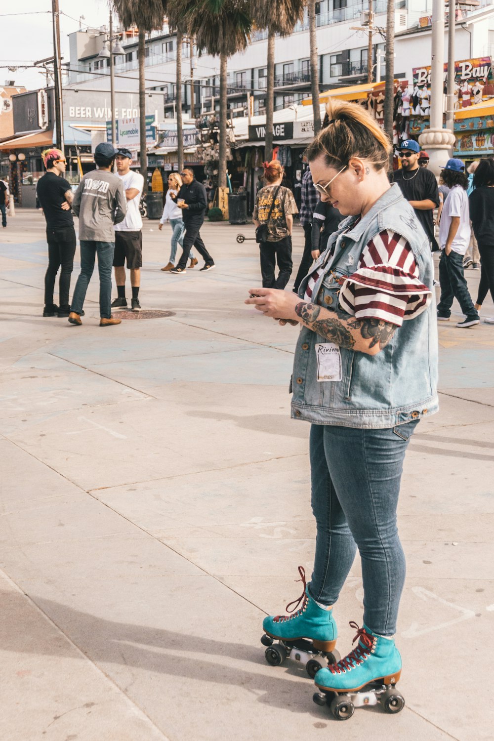 woman in roller skates using smartphone near people