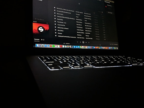 A vibrant image showing a music artist uploading tracks on a laptop with streaming platforms logos around.