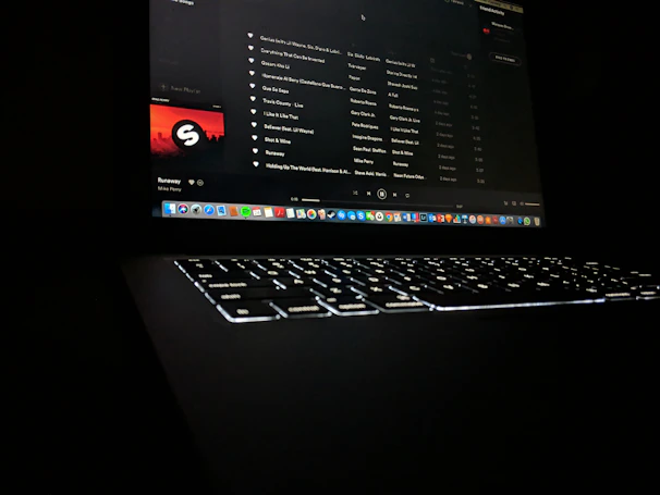 A sleek laptop screen showing the believe tune dashboard with song upload in progress.
