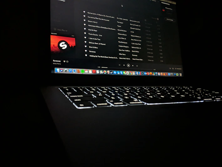 A dark-themed video player interface with red and black accents showing a music video paused on a dramatic scene.