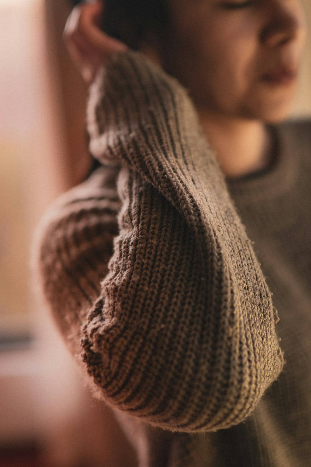 person wearing brown knit sweater