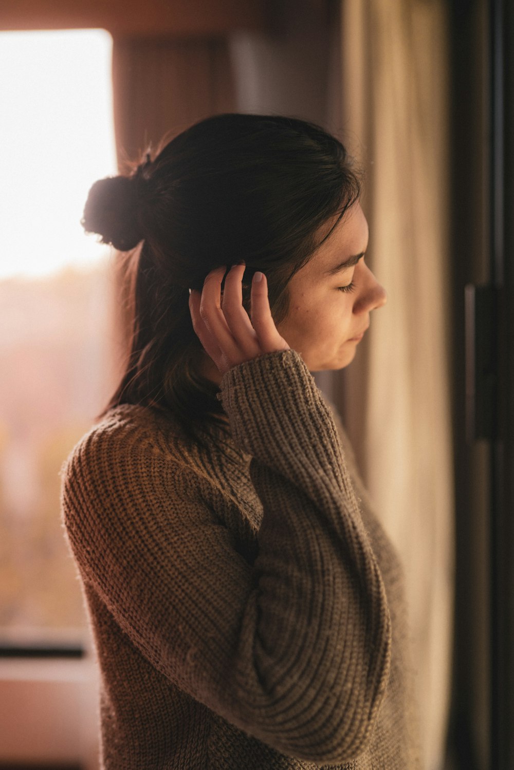 selective focus photography of woman touching hair