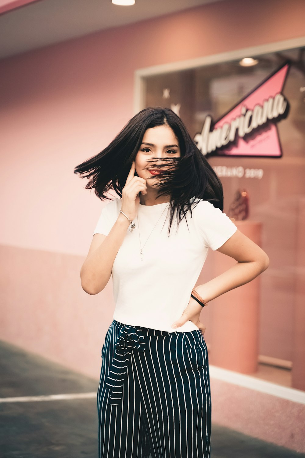 woman wearing white crew-neck t-shirt and black-and-white striped bottoms