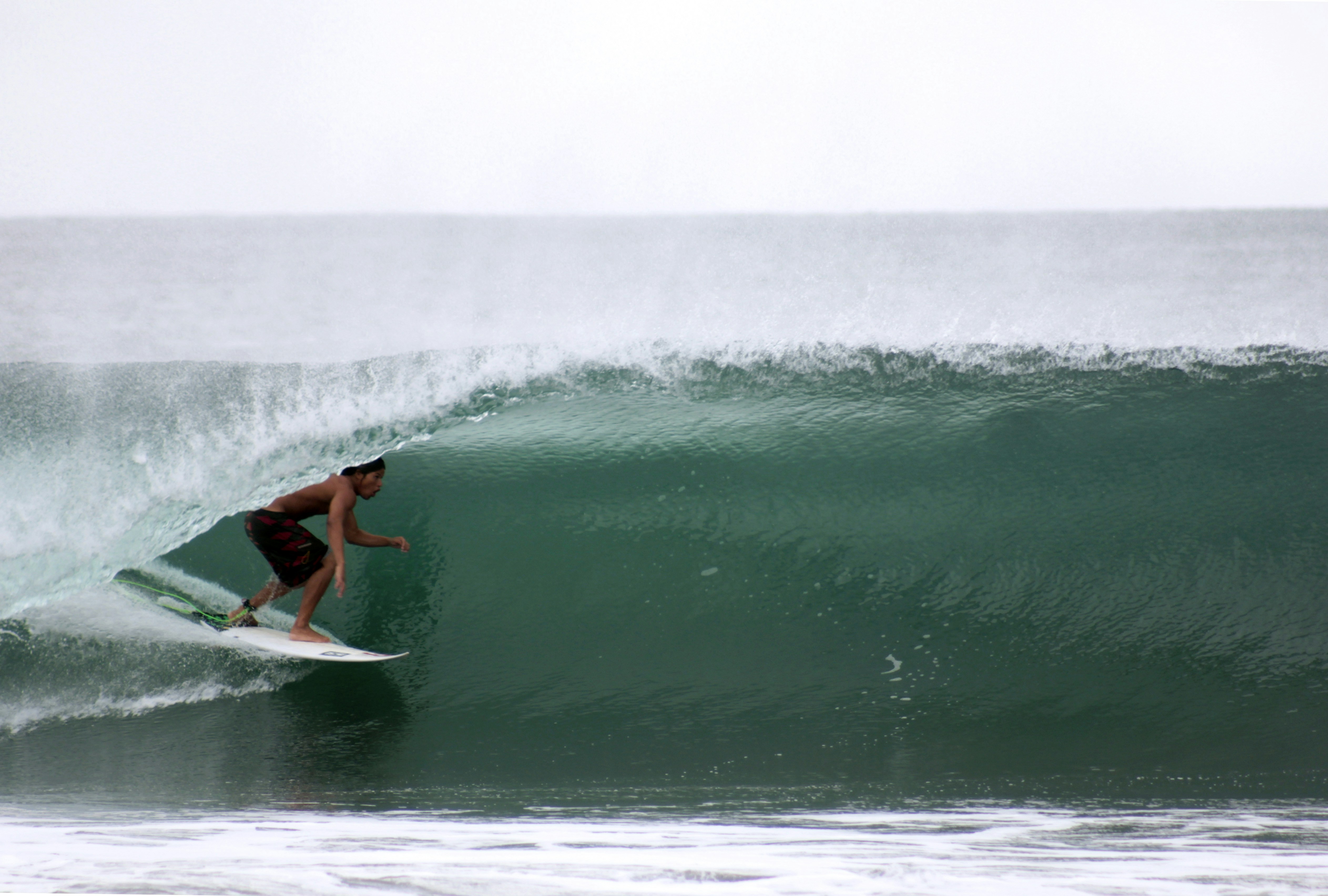 man riding white surfboard