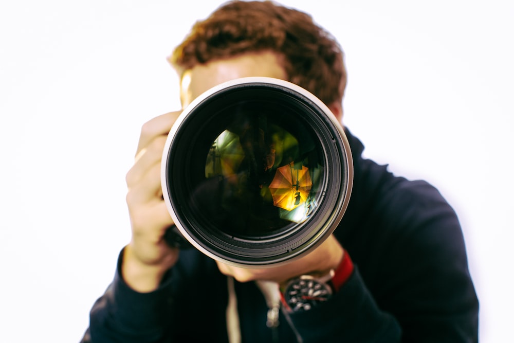 man wearing black jacket using black DSLR camera