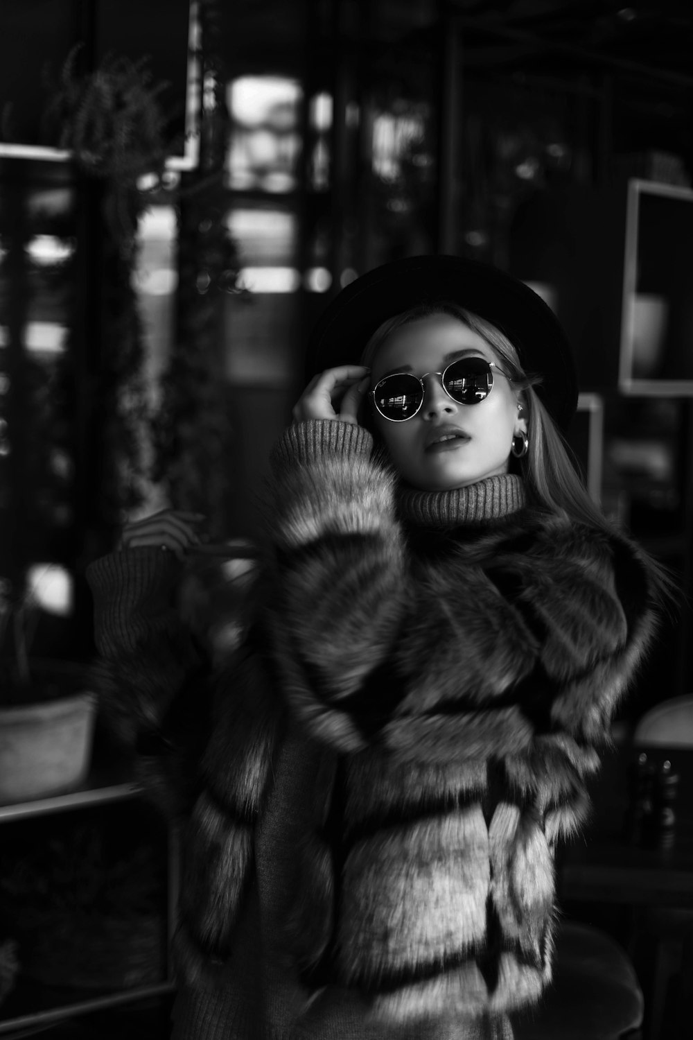 grayscale photo of woman wearing coat and sunglasses