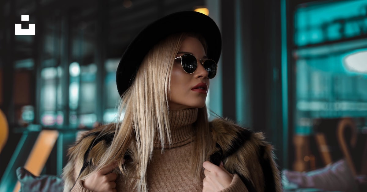 Woman wearing brown turtleneck sweater, black hat and black sunglasses ...