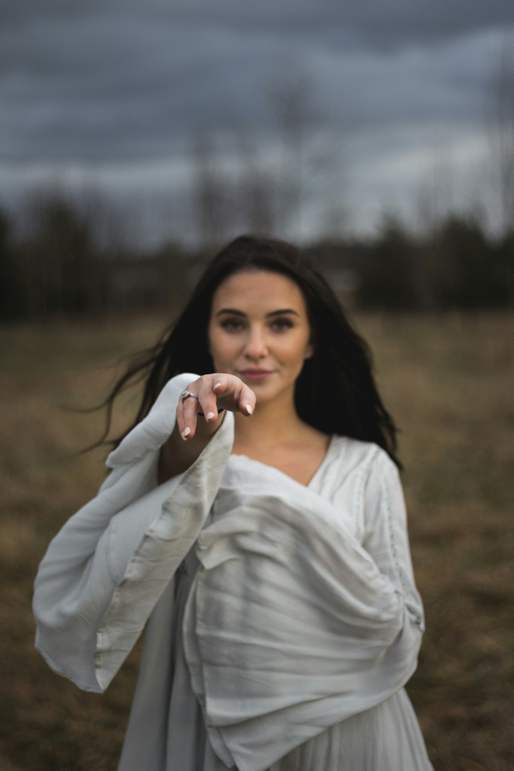 selective focus photography of woman reaching right hand during daytime