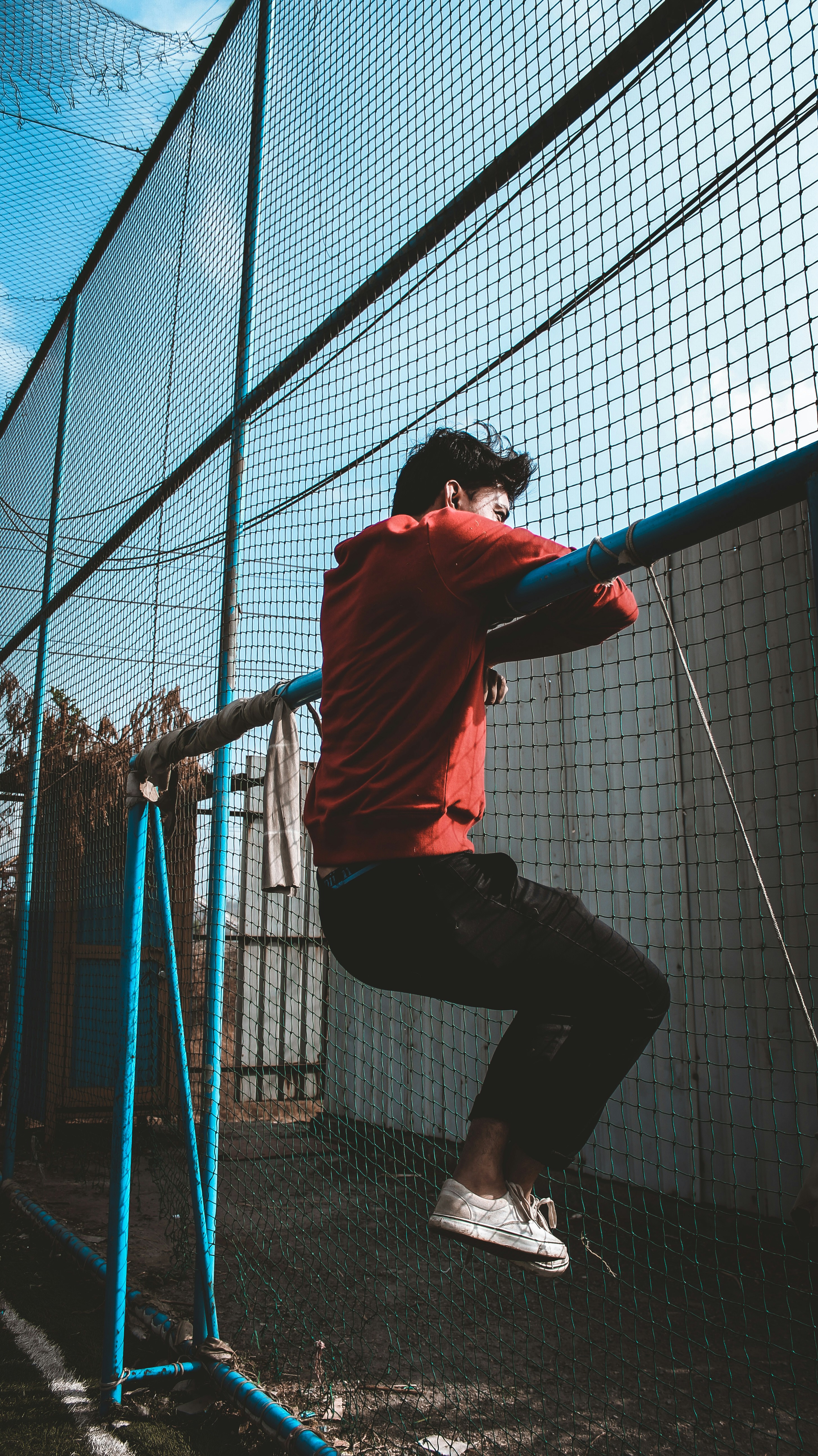 person hanging blue steel rail