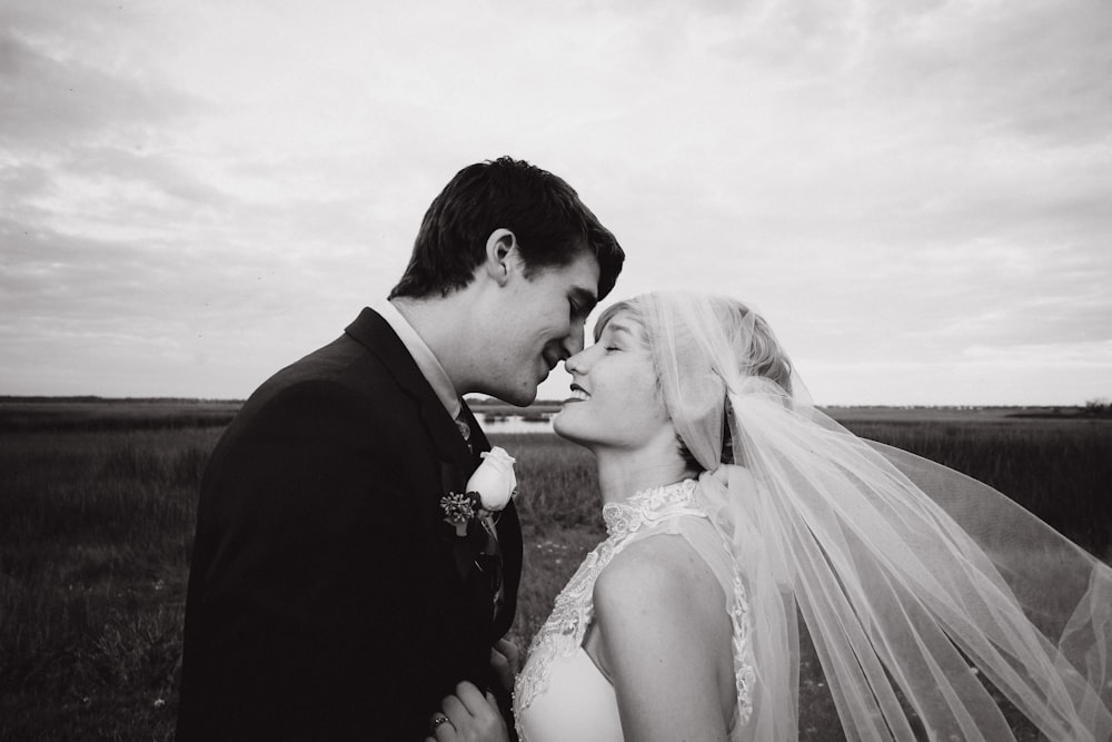 grayscale photo of man and woman kissing